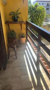 a balcony with a bench and potted plants at Aconchegante casa piuma in Piúma +1 photo