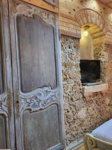 a large wooden door in a room with a stone wall at La Garette in Elbeuf-sur-Andelle