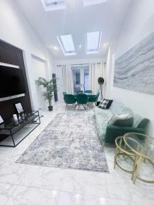 a living room with a couch and a table at Modern Luxury 2 Bed and Private Studio Room with Parking in Catford
