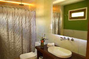 a bathroom with a sink and a toilet and a mirror at Las Loicas Chalten Apart in El Chalten +23 photos