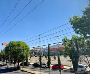 a parking lot with cars parked in front of a building at Departamento acogedor, moderno y céntrico in Apizaco