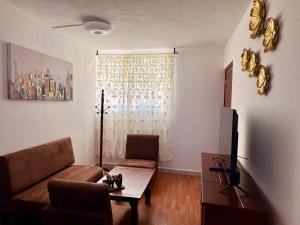a living room with a couch and a table at Departamento acogedor, moderno y céntrico in Apizaco