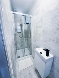 a bathroom with a shower and a toilet and a sink at Modern Luxury 2 Bed and Private Studio Room with Parking in Catford