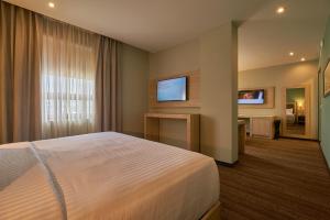 a hotel room with a bed and a flat screen tv at Wyndham Garden Saltillo in Saltillo