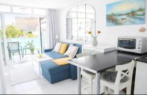 a living room with a blue couch and a table at New Puerto Rico Terrace Swiming Pool in Mogán