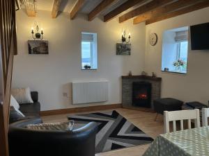 a living room with a couch and a fireplace at Ysgubor Ddegwm Bach in Beaumaris