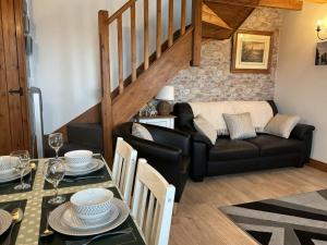 a living room with a couch and a table at Ysgubor Ddegwm Bach in Beaumaris