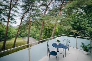 a table and chairs on a balcony with trees at Ośrodek TVP in Ciechocinek