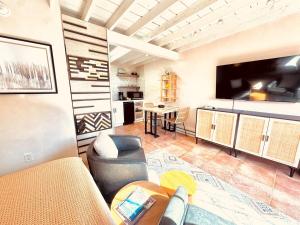 a living room with a couch and a tv and a table at Serenity in Santa Fe