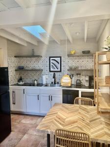 a kitchen with white cabinets and a wooden table at Serenity in Santa Fe