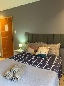 a bedroom with a bed with towels on it at Excelente Espaço Econômico em Laranjeiras in Rio de Janeiro