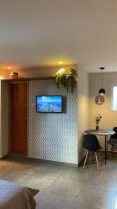 a bedroom with a tv on a wall with a table at Excelente Espaço Econômico em Laranjeiras in Rio de Janeiro
