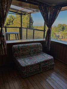 a living room with a couch and a large window at Casona de Campo in Puerto Varas