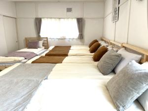 a group of four beds in a room at Local Stay Hakodate in Hakodate