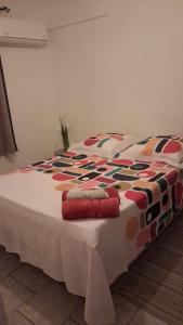 a bed with a colorful blanket on top of it at Le Lys de la paix in Le Morne Rouge