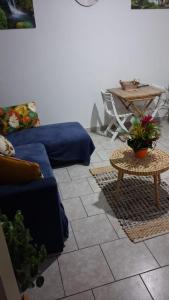a living room with a blue couch and a table at Le Lys de la paix in Le Morne Rouge +5 photos