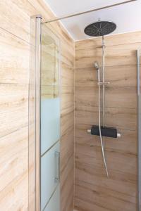 a shower in a bathroom with wooden walls at Studio MORGINS avec piscine Gratuite in Morgins +7 photos
