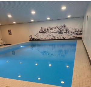 a large swimming pool with a painting on the wall at Studio MORGINS avec piscine Gratuite in Morgins
