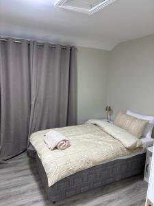 a bed in a white room with curtains at Deelview in Eas Géitine
