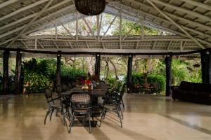 a dining room with a table and chairs in a pavilion at Hotel Bohemian Lagarto in Santa Cruz