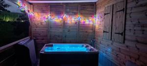a hot tub in a room with christmas lights at Plenitude Bungalow in Sainte-Rose