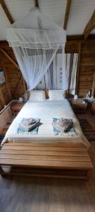 a bedroom with a bed with two fishnets on it at Plenitude Bungalow in Sainte-Rose