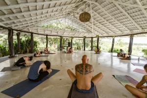 a group of people doing yoga in a building at Hotel Bohemian Lagarto in Santa Cruz