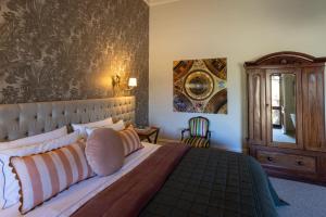 a bedroom with a large bed and a painting on the wall at St Agnes by Prunella in Kyneton +14 photos