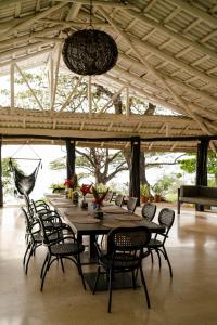 a large wooden table with chairs in a pavilion at Hotel Bohemian Lagarto in Santa Cruz