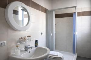 a bathroom with a sink and a toilet and a mirror at Maison Geraldine in Marcianise +18 photos