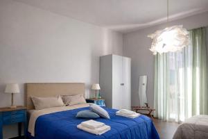 a bedroom with a bed with blue sheets and a chandelier at Maison Geraldine in Marcianise