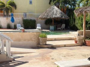 a patio with a umbrella and chairs and a pool at Casa Sol-Oasis del Mar in Progreso