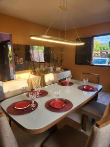 a dining room table with red plates and glasses on it at Espaço Sunshine in Saquarema