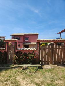 a house with a wooden fence in front of it at Espaço Sunshine in Saquarema