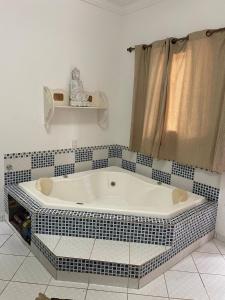 a bath tub in a bathroom with a tiled wall at Chateau Magalhães in Itatiba +11 photos