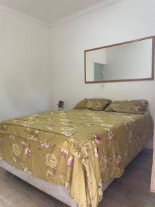 a bedroom with a bed with a yellow comforter at Chateau Magalhães in Itatiba