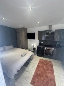 a bedroom with a large bed and a kitchen at Spacious Luxury 2bd with extra Private Studio Room in Catford +8 photos