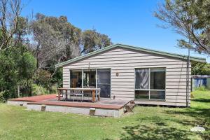 a small house with a picnic table on a deck at The Ash, Sandy Point Stay 3 Pay 2 Winter Special in Sandy Point