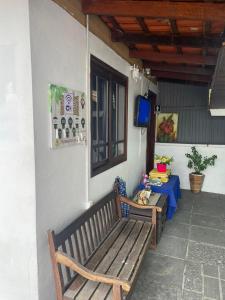 a porch with two wooden benches and a table at Pousada Joinville in Joinville