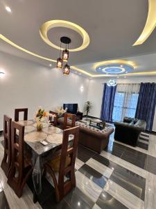 a living room with a table and a couch at Résidence Prestige KGV 1er lot de 14 appartements meublés in Douala