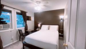 a bedroom with a white bed and a window at Cornerstone Bed and Breakfast in Revelstoke
