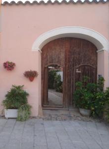 una entrada a un edificio con un arco y plantas en B&B Casa Licheri, en San Vito