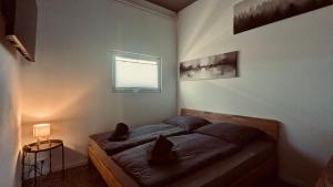 a bedroom with a bed with two pillows and a window at Das Atelier - Kunstvoll verweilen in Ichtershausen