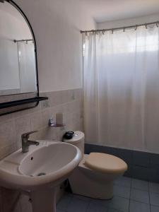 a bathroom with a sink and a toilet and a shower at KUSIHaus in Lima