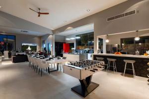 a kitchen and living room with tables and a bar at STK Villa Samui Paradise Awaits in Nathon Bay