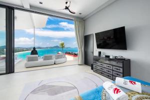 a living room with a large window with a view of the ocean at STK Villa Samui Paradise Awaits in Nathon Bay