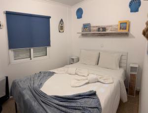 a bedroom with a white bed with towels on it at Shell's Apartment in Praia do Carvoeiro
