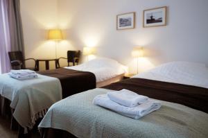 a hotel room with two beds with towels on top at Hotel Korpoström in Korpoström