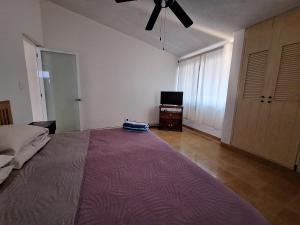 a bedroom with a large bed and a ceiling fan at Casa Sol-Oasis del Mar in Progreso