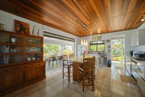 a kitchen with a wooden ceiling and a table and chairs at Enjoy Camanukea Lodge in Mahina